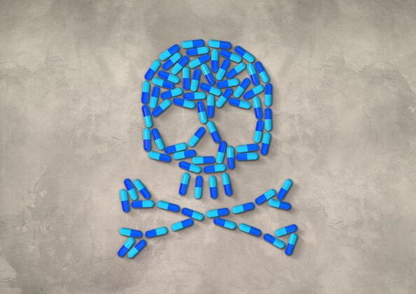 医学头骨由蓝色的胶囊药丸制成 隔离在混凝土背景上处方抗生素混凝土