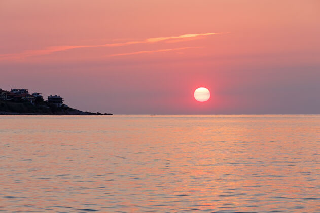 天日出海景（粉红色天空中的太阳和它在水面上的反射）黎明涟漪阳光