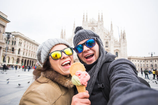 亲吻在米兰的大教堂里 一对有趣的情侣拿着冰淇淋自拍自拍大教堂男人