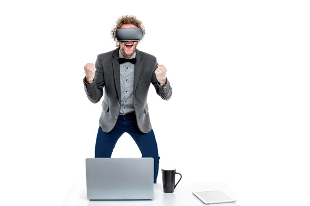科技卷发优雅商人的肖像 戴着vr眼镜 手握拳放在桌上的椅子上 手里拿着小玩意男人平板电脑小玩意