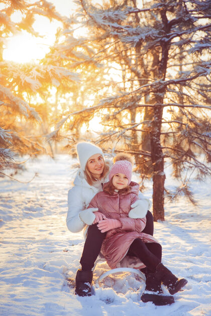 成人妈妈和女儿在冬季公园玩得很开心公园幼儿女人