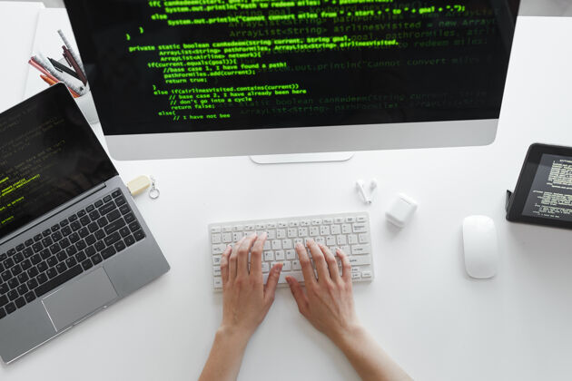 系统开发人员在电脑键盘上打字的高角度视图在桌旁的电脑上安装新系统文档数据办公桌