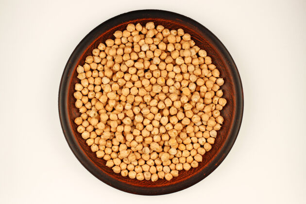 干的鹰嘴豆在盘子里放在白色的表面上蔬菜生的营养