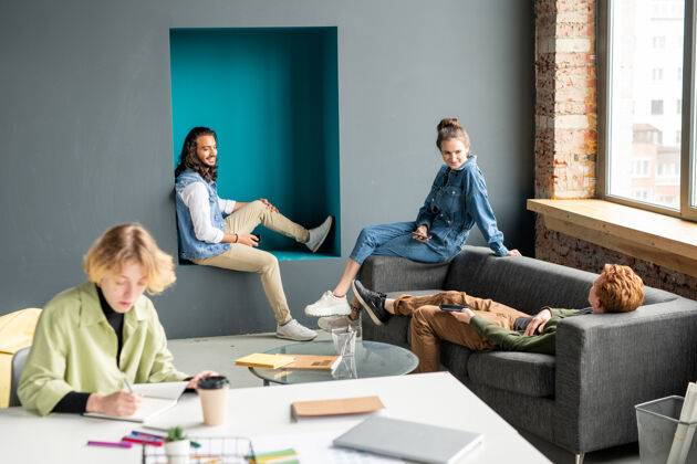 计划快乐的年轻创意设计师穿着休闲装坐在办公室的窗前 在会议上集思广益 讨论工作要点女性坐着男性