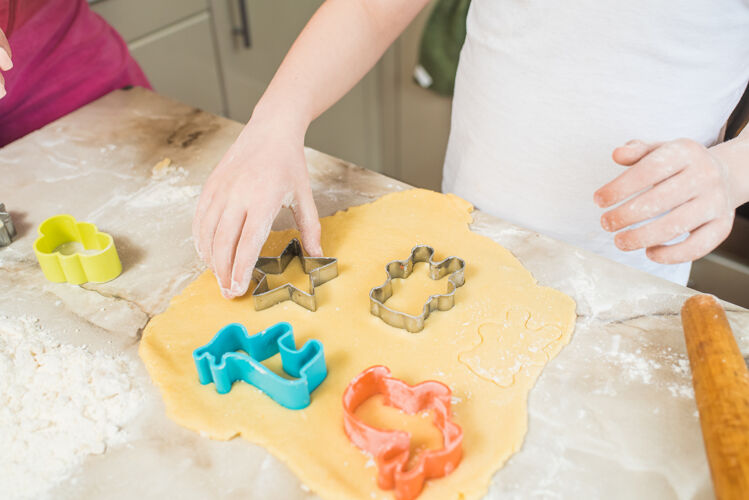 孩子孩子的手在面团上捏饼干在家做饭厨房制作准备
