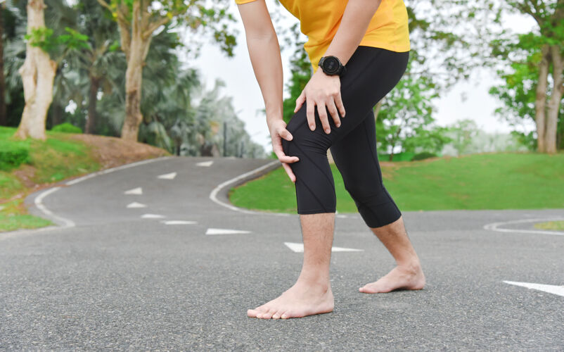 道路亚洲年轻运动员在户外运动中肌肉和关节疼痛 过度训练或跑步和运动不公平的概念特写膝盖损伤疼痛