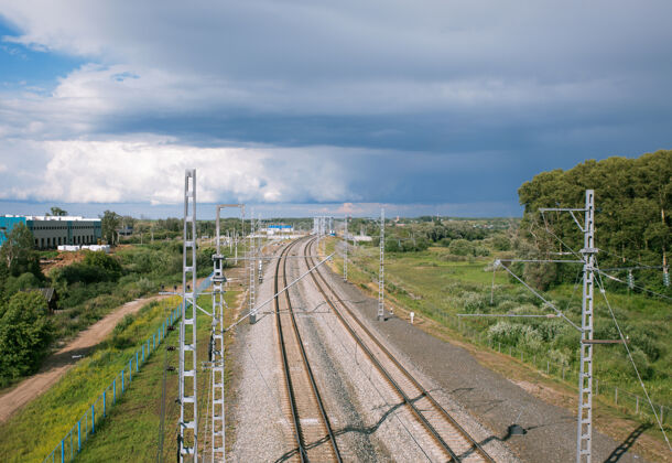 通勤铁路线延伸到地平线上 背景是多云的天空地平线铁路轨道