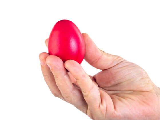 手红色的复活节彩蛋在女人的手上孤立在白色的心举行新鲜