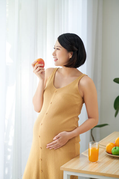 女性健康的饮食为我和我的宝宝美丽的孕妇吃水果沙拉和微笑中国食物水果