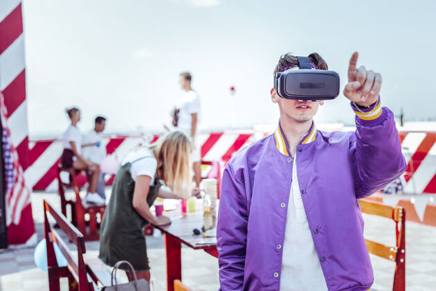 实相虚拟现实年轻人戴着电子面具 指着一些奇怪的东西互动科技上瘾