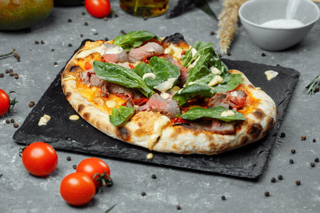 自制肉意大利披萨配烤牛肉 牛排片 融化的奶酪 橄榄片和切达奶酪肉切片餐厅