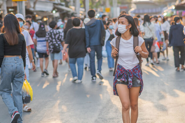 步行街上戴着面具的女孩亚洲背包防护