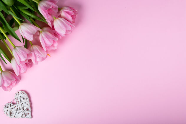 复制空间粉红色背景上有一束郁金香和红心顶视图 平铺风格浪漫花粉红色