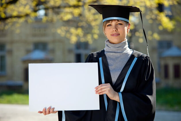 朋友手里拿着一张白纸的大学毕业生礼服学位女性