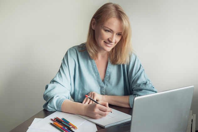 色彩一个金发女人在一个在线课程上画册电脑绘画铅笔