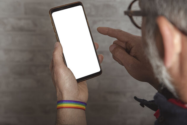 通信用智能手机拍下男性手戴lgbt手镯的特写镜头手持拇指网络