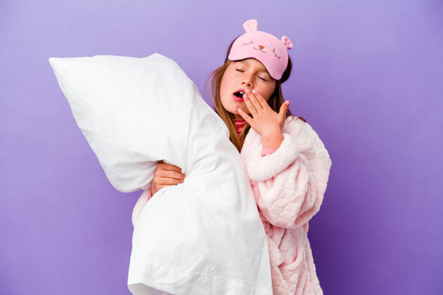 人小女孩抱着一个枕头快乐地孤立在紫色上早晨孩子气孩子