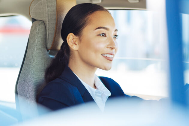 积极女出租车司机工作时坐在方向盘后面的可爱的年轻女子休闲亚洲人赛车