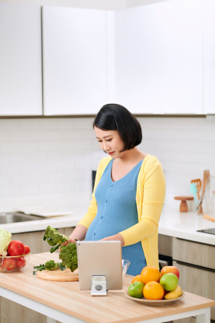 早餐孕妇切花椰菜做新鲜蔬菜沙拉 为未来母亲提供健康营养亚洲女人平板电脑