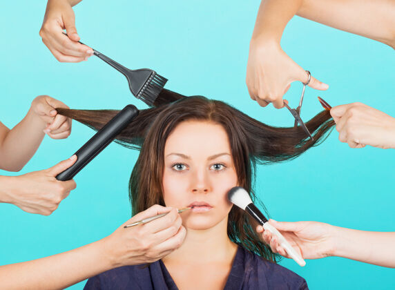 刷子女孩化妆和头发由许多手概念的多任务化妆卷发器理发师多任务