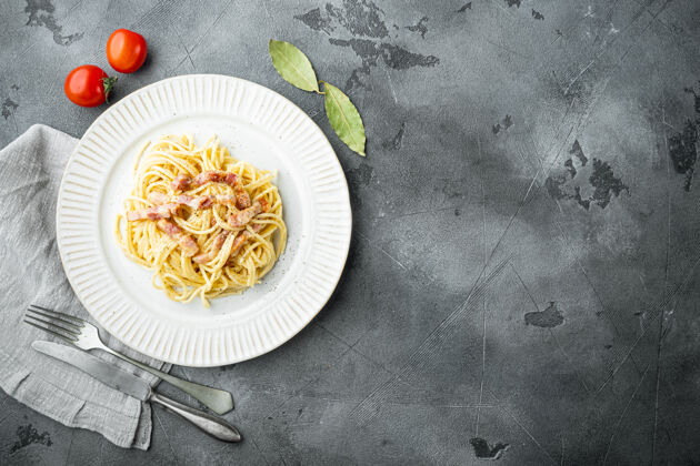 细节经典的自制意大利面 配培根 鸡蛋 帕尔马干酪 放在灰色石桌上 俯视平面 有复印空间美食石头美味