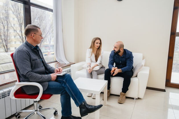 访问一对年轻的已婚男女在一次心理治疗中与一位心理学家交谈心理学咨询同情精神病医生