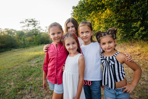 吹日落时分 一群快乐的女孩在公园里微笑玩耍儿童夏令营活跃友谊肖像
