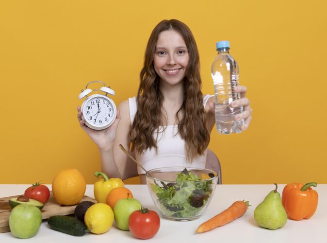 健康中等身材的女人 带着蔬菜和水食物饮食女人