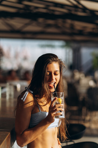 女人在沙滩酒吧休息的女人喝一杯清爽的鸡尾酒度假村酒精女士