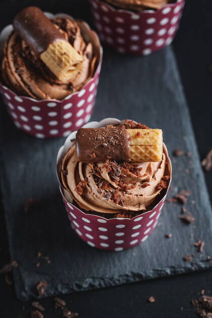 豪华美味的巧克力松饼纸杯蛋糕加奶油装饰在杯子里特写面包房餐饮糖果