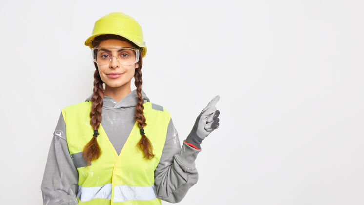 站立专业女工工程师 身着工作服 戴防护头盔 透明眼镜和手套 在复印区展示建筑工程理念技术制造眼镜