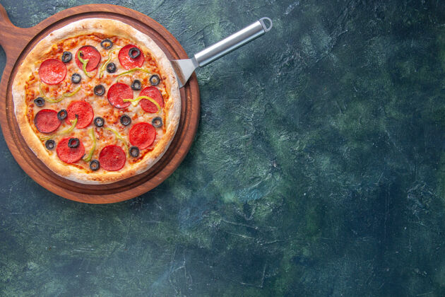 比萨饼美味的自制披萨在黑暗的表面上切木板在右边板金属时间
