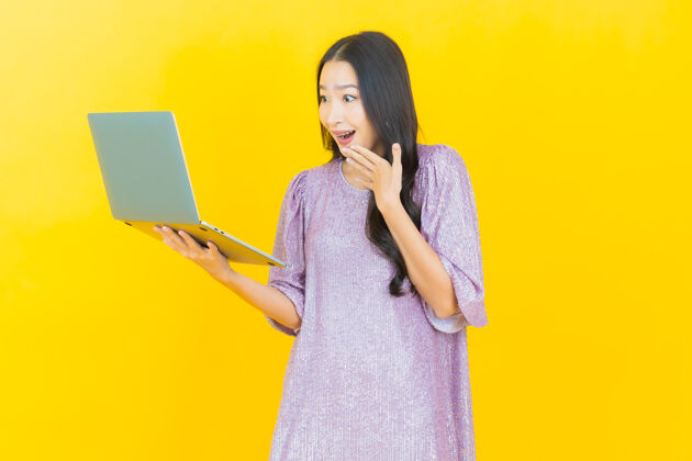 人员年轻的亚洲女人微笑着拿着笔记本电脑成年人欢呼笔记本电脑