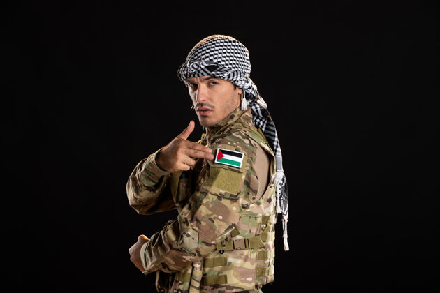 伪装在黑墙上伪装的巴勒斯坦士兵成人黑人青年