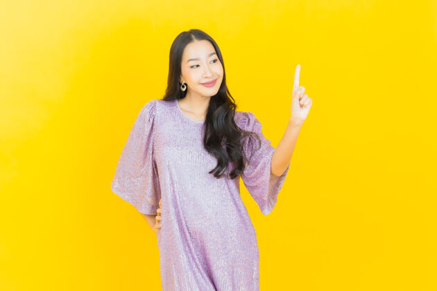 模特年轻的亚洲女人在黄色的脸上微笑肖像女性乐趣