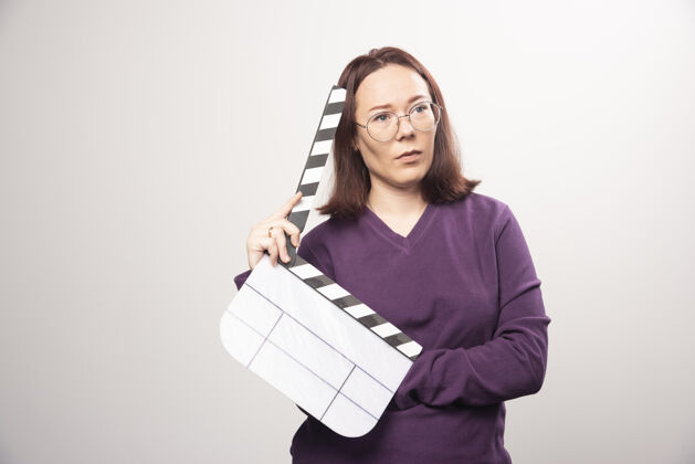 女士一个年轻的女人在一张白色的照片上摆着一个电影院的带子高质量的照片女人镜头姿势