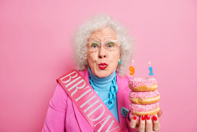 享受美丽的女性退休者的画像 嘴唇圆润 想吻你 感谢你 穿着得体 手里拿着一堆美味的甜甜圈女士老年人皱纹