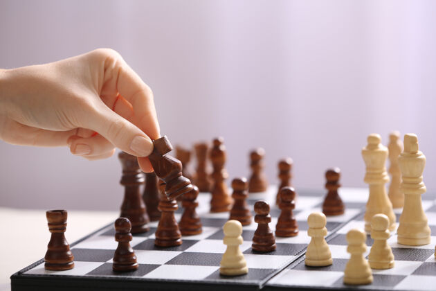 胜利女人下棋的手上光线模糊检查移动国王