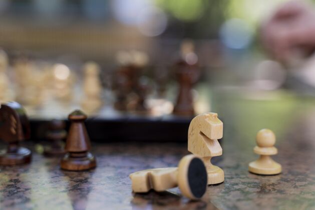 特写关闭模糊的手和棋子退休国际象棋游戏