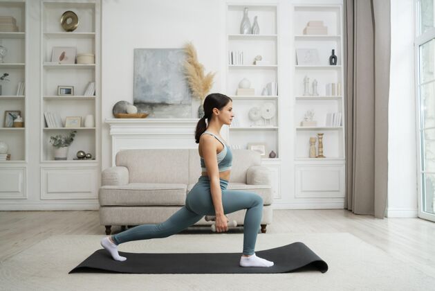 生活方式在家里用健身垫锻炼的年轻女子在家锻炼健康运动