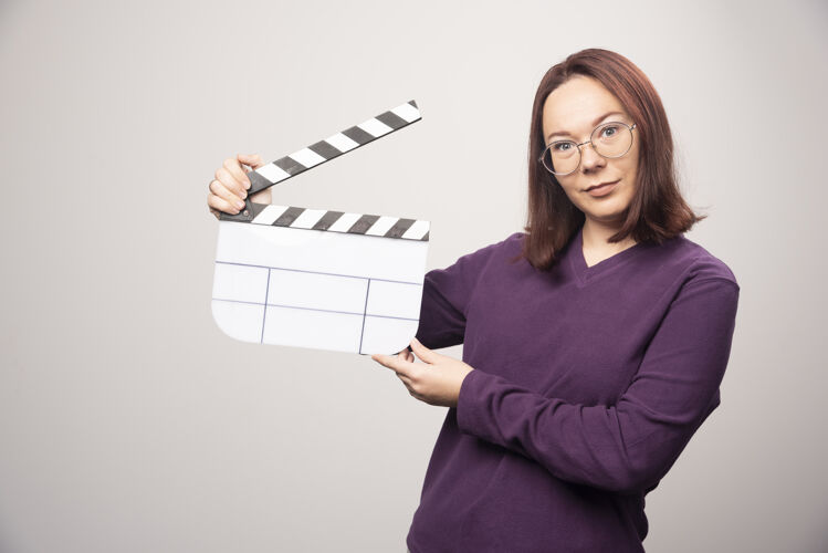 女人一个年轻的女人在一张白色的照片上摆着一个电影院的带子高质量的照片姿势模型女士
