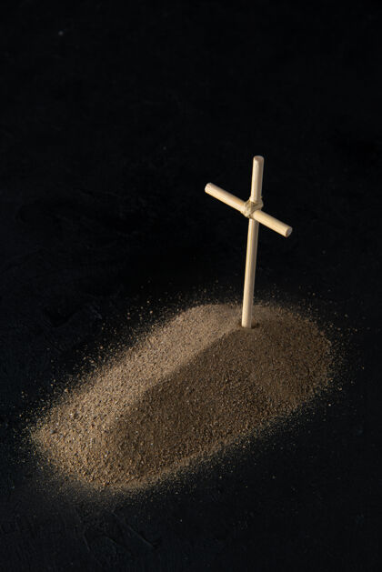 死亡从沙子上看到的小坟墓的正面图 黑色的十字架沙子黑暗葬礼