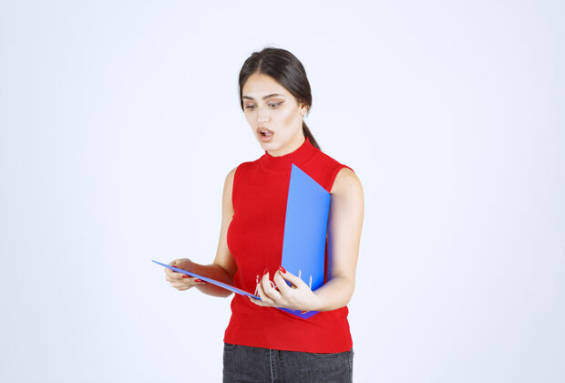 服装穿着红衬衫的女孩手里拿着一个蓝色的商业文件夹人类助理女人