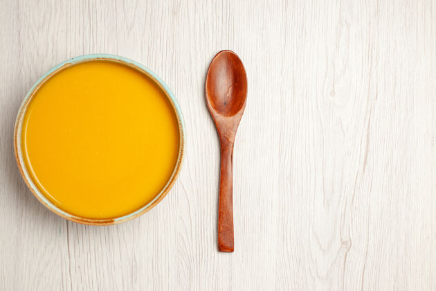 颜色俯瞰美味的奶油汤黄色汤白色木桌上汤酱饭奶油晚餐菜刀视图烹饪