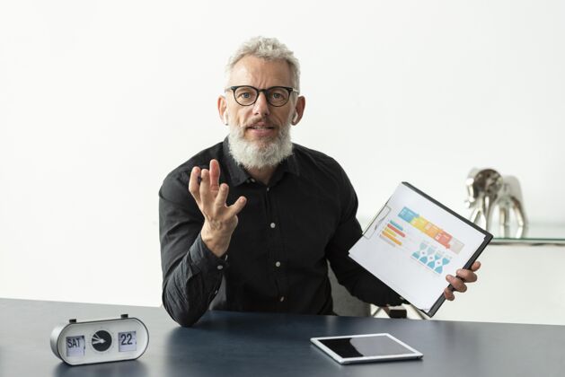 男性家里的老人在笔记本上展示图表 桌上放着平板电脑成熟设备老年人