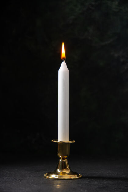 火在黑色的金色的立场上白色蜡烛的正面视图葬礼死亡光