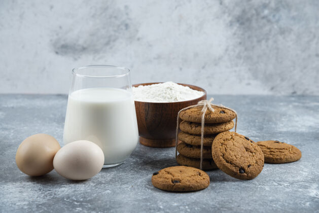 食物一杯热牛奶和美味的饼干放在一张灰色的桌子上牛奶美味糕点