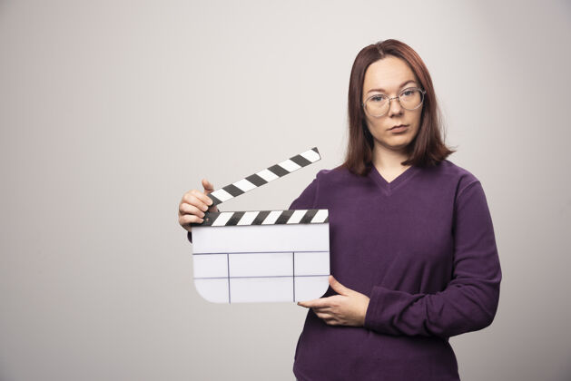 磁带一个年轻的女人在一张白色的照片上摆着一个电影院的带子高质量的照片模型女性女士