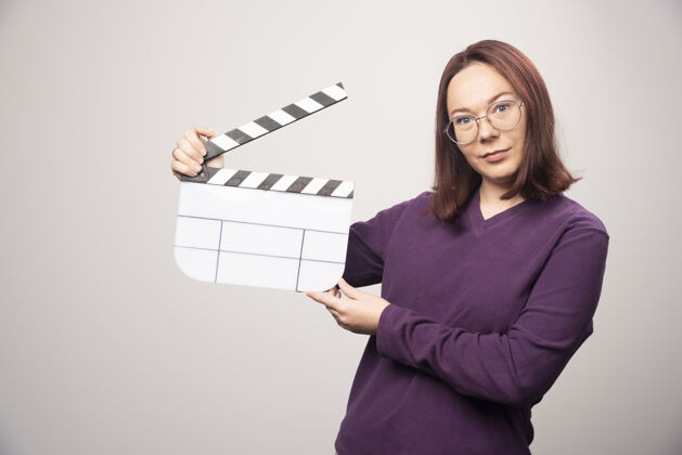 女人一个年轻的女人在一张白色的照片上摆着一个电影院的带子高质量的照片姿势模型女士