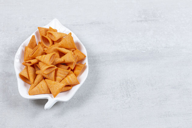 三角美味的三角片放在叶子形状的盘子上美味咸薯条
